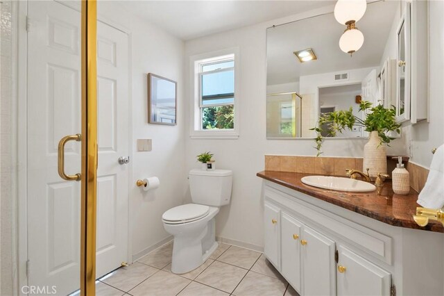 1525 E Baldwin Ave, Orange, CA 92865 - bathroom featuring vanity, a shower stall, tile patterned flooring, toilet, and baseboards