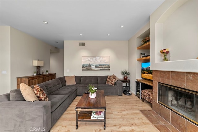 823 Sonora Ct, San Dimas, CA 91773 - living area featuring light wood-style flooring, recessed lighting, a tiled fireplace, built in features, and baseboards