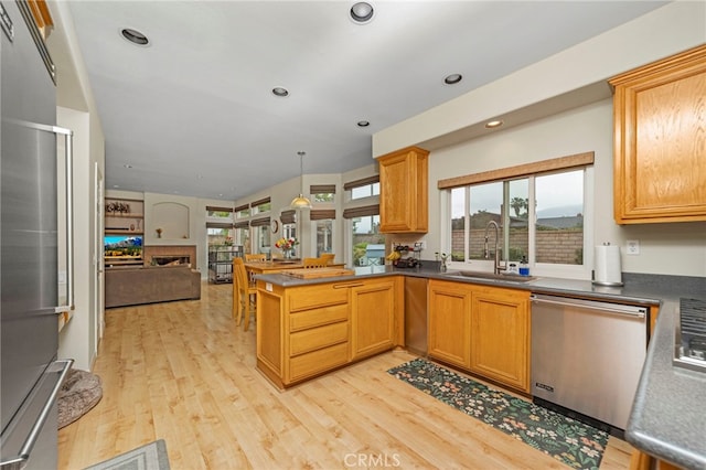 823 Sonora Ct, San Dimas, CA 91773 - kitchen featuring stainless steel appliances, a sink, open floor plan, a peninsula, and light wood finished floors