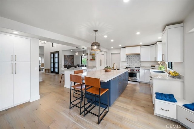 5805 Salisbury Ln, San Luis Obispo, CA 93401 - kitchen featuring stainless steel stove, light wood-type flooring, a sink, a kitchen bar, and recessed lighting