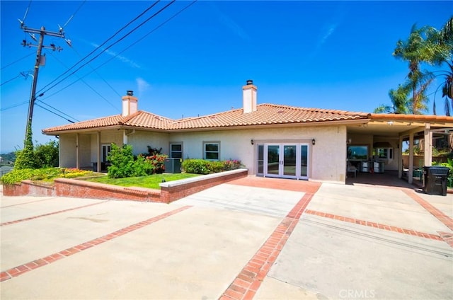 2036 S Buenos Aires Dr, Covina, CA 91724 - back of house featuring stucco siding, a chimney, driveway, and french doors