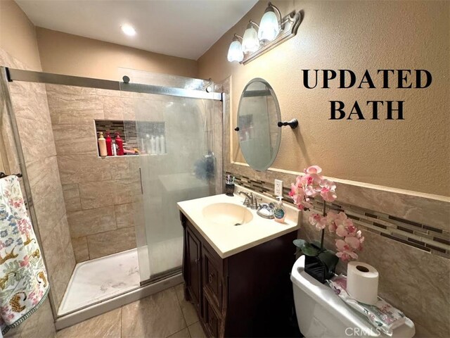 5246 N Clydebank Ave, Azusa, CA 91702 - bathroom with a shower stall, toilet, vanity, and a textured wall