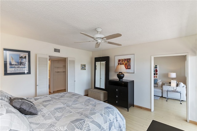 277 E Alejo Rd Unit 212, Palm Springs, CA 92262 - bedroom featuring light wood finished floors, a textured ceiling, and ceiling fan