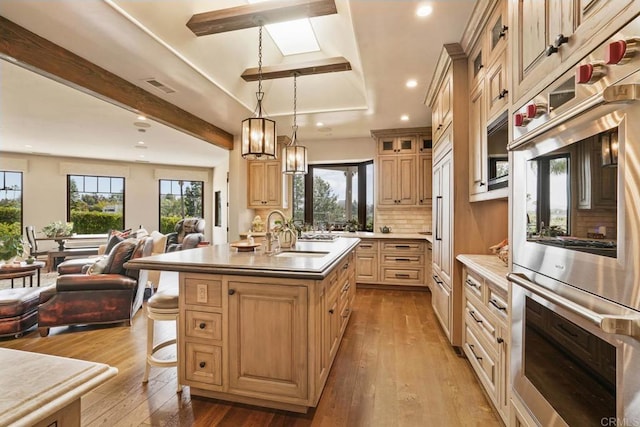 4652 Resmar Rd, La Mesa, CA 91941 - kitchen featuring open floor plan, a sink, double oven, hardwood / wood-style flooring, and a kitchen island with sink