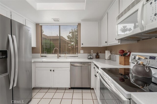 28 Malaga Dr, Rancho Mirage, CA 92270 - kitchen with appliances with stainless steel finishes, a sink, light countertops, white cabinets, and a tray ceiling