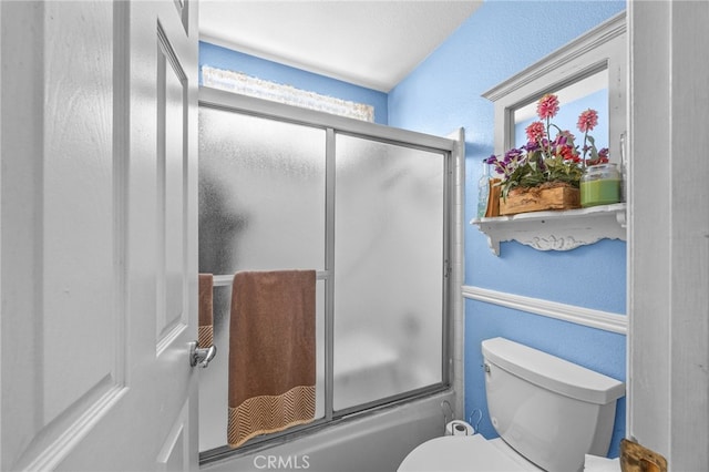 17477 Owl Tree Rd, Riverside, CA 92504 - full bathroom with a textured wall, toilet, and combined bath / shower with glass door