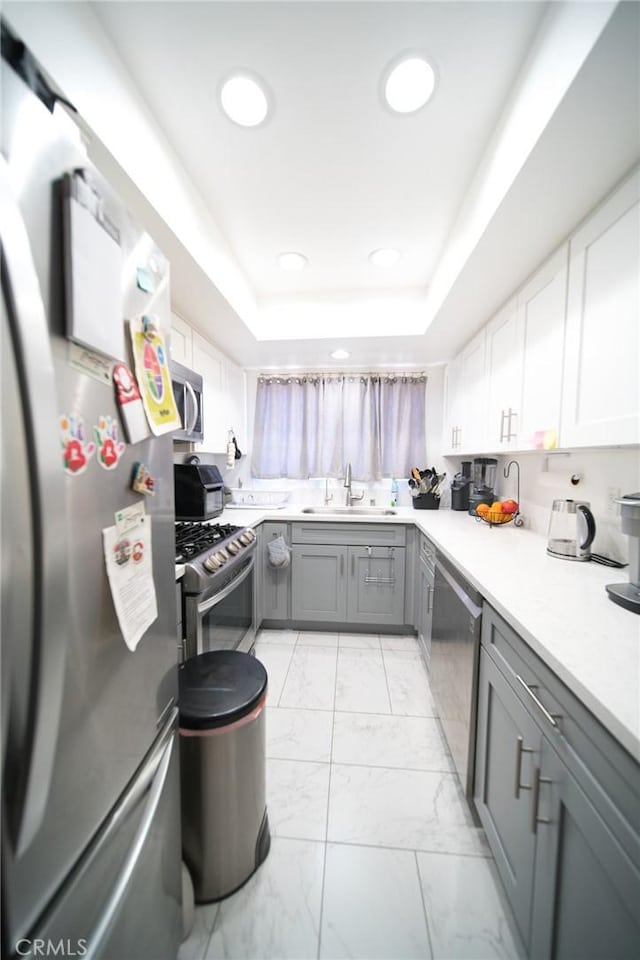 532 Venice Way Unit 8, Inglewood, CA 90302 - kitchen with stainless steel appliances, a sink, gray cabinetry, light marble finish floors, and a tray ceiling