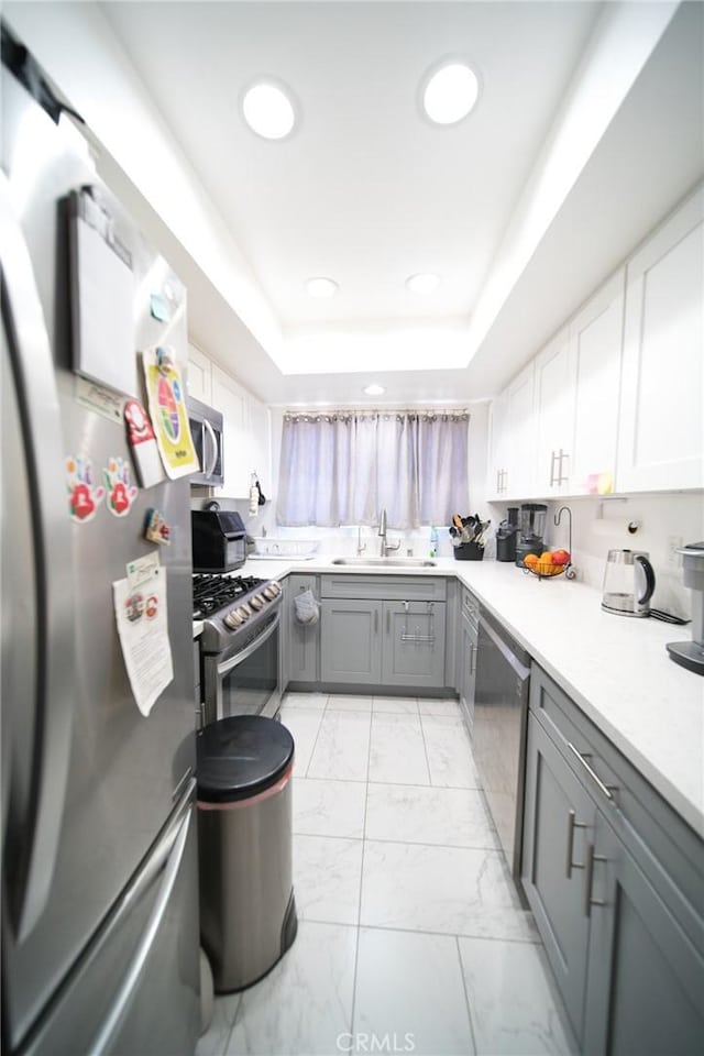 532 Venice Way Unit 8, Inglewood, CA 90302 - kitchen featuring stainless steel appliances, gray cabinetry, light marble finish floors, a tray ceiling, and light countertops
