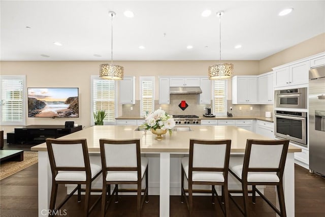 1252 N Lindley St, Azusa, CA 91702 - kitchen featuring oven, under cabinet range hood, decorative backsplash, light countertops, and white cabinets