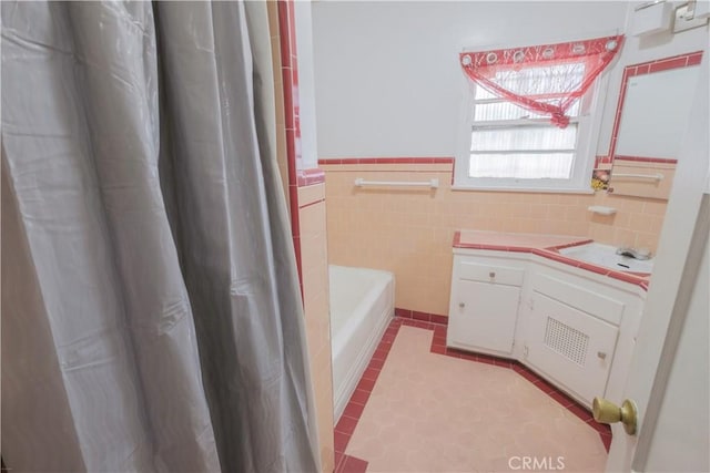 1248 E 65th St, Los Angeles, CA 90001 - bathroom featuring a bath, wainscoting, vanity, tile patterned flooring, and tile walls