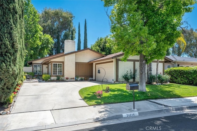 24214 Dalgo Dr, Valencia, CA 91355 - view of front of house with stucco siding, a chimney, a front lawn, an attached garage, and driveway