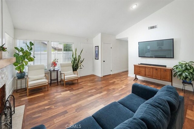 24214 Dalgo Dr, Valencia, CA 91355 - living area with a fireplace with flush hearth, vaulted ceiling, wood finished floors, baseboards, and recessed lighting