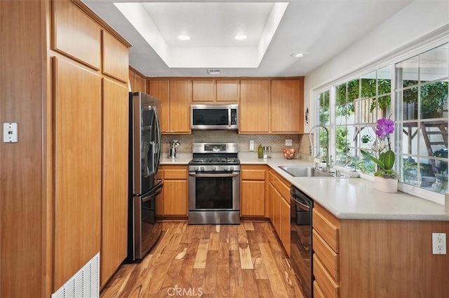 24214 Dalgo Dr, Valencia, CA 91355 - kitchen with appliances with stainless steel finishes, a sink, light wood-style flooring, tasteful backsplash, and light countertops