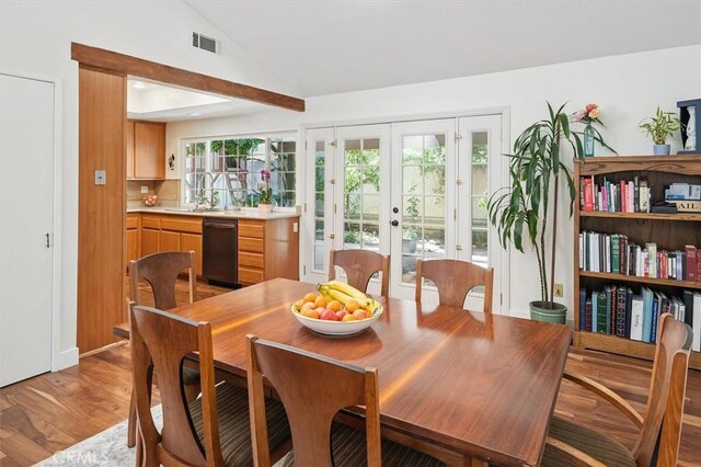 24214 Dalgo Dr, Valencia, CA 91355 - dining area with french doors, lofted ceiling, and light wood-style floors