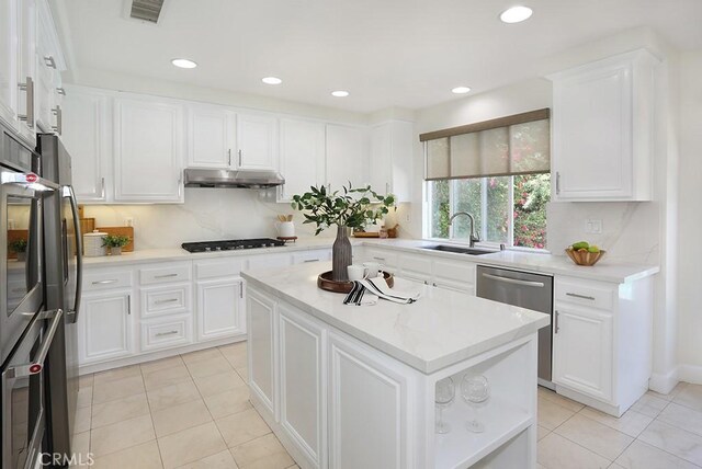 1019 N Sonora Cir, Orange, CA 92869 - kitchen with dishwasher, under cabinet range hood, black gas stovetop, light tile patterned flooring, and white cabinets