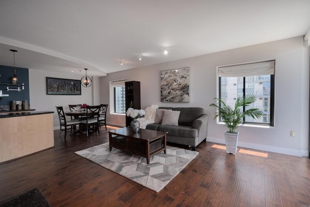 1333 8th Ave Unit 905, San Diego, CA 92101 - living room featuring plenty of natural light, dark wood-style flooring, baseboards, and a chandelier