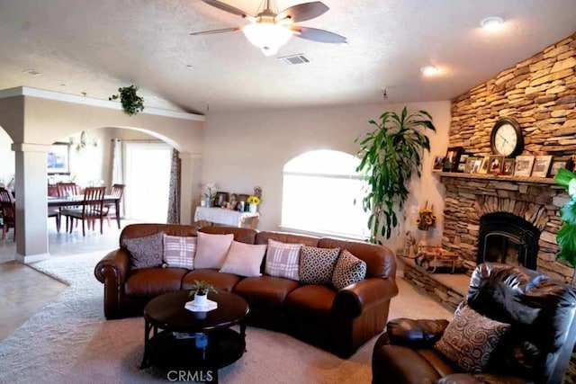 12720 Farmington St, Oak Hills, CA 92344 - living area with arched walkways, vaulted ceiling, a ceiling fan, and a stone fireplace