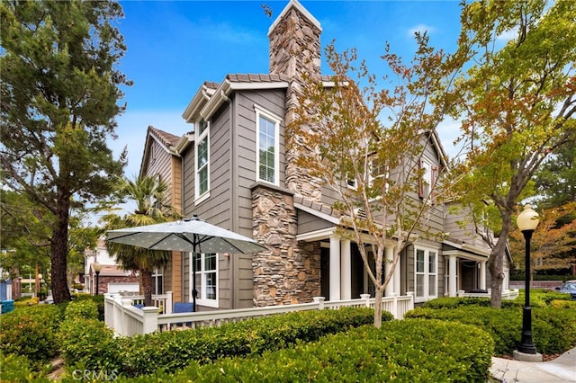 25 Ellsworth St Unit 11, Ladera Ranch, CA 92694 - rear view of house featuring a chimney and stone siding