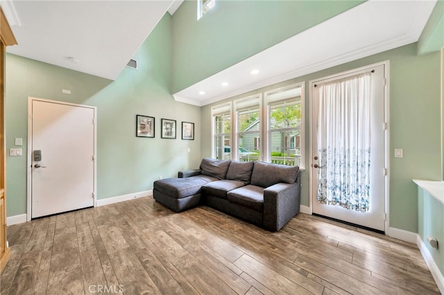 25 Ellsworth St Unit 11, Ladera Ranch, CA 92694 - living room featuring baseboards, crown molding, hardwood / wood-style floors, recessed lighting, and a towering ceiling