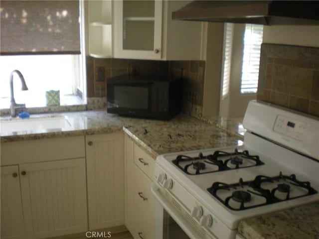 28265 La Bajada, Laguna Niguel, CA 92677 - kitchen featuring gas range gas stove, black microwave, extractor fan, white cabinets, and glass insert cabinets