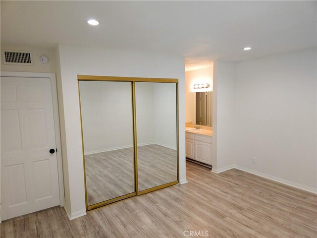 4734 Park Granada Unit 238, Calabasas, CA 91302 - unfurnished bedroom with light wood finished floors, a closet, a sink, baseboards, and recessed lighting