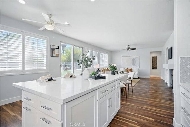 27170 Arrow Point Trl, Corona, CA 92883 - kitchen with ceiling fan, baseboards, white cabinetry, a kitchen island, and dark wood-style floors