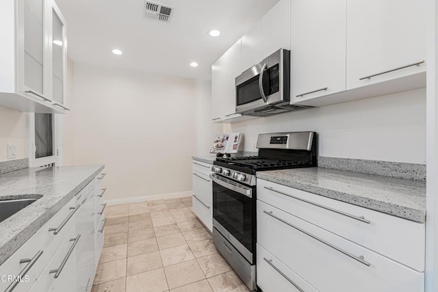 15233 Camarillo St, Sherman Oaks, CA 91403 - kitchen featuring stainless steel appliances, white cabinets, recessed lighting, light stone counters, and baseboards
