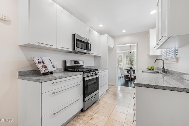 15233 Camarillo St, Sherman Oaks, CA 91403 - kitchen featuring appliances with stainless steel finishes, a sink, white cabinets, recessed lighting, and light stone countertops