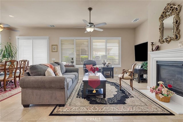 19423 Crystal Springs Ln, Apple Valley, CA 92308 - living room featuring a ceiling fan, plenty of natural light, a glass covered fireplace, and light tile patterned floors