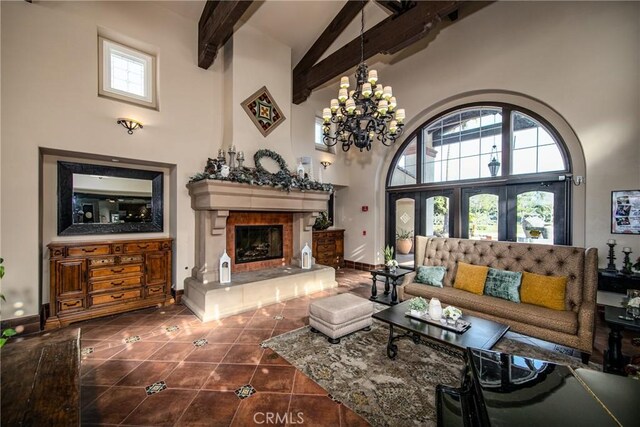 317 Calvert Park, Beaumont, CA 92223 - living room featuring high vaulted ceiling, beamed ceiling, tile patterned flooring, a fireplace with raised hearth, and a chandelier
