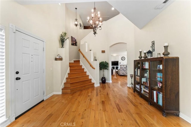 25300 Heather Vale St, Saugus, CA 91350 - foyer entrance featuring arched walkways, high vaulted ceiling, stairway, light wood-type flooring, and a chandelier