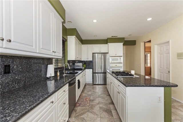 213 Caldera St, Perris, CA 92570 - kitchen with appliances with stainless steel finishes, a sink, white cabinets, a kitchen island, and tasteful backsplash