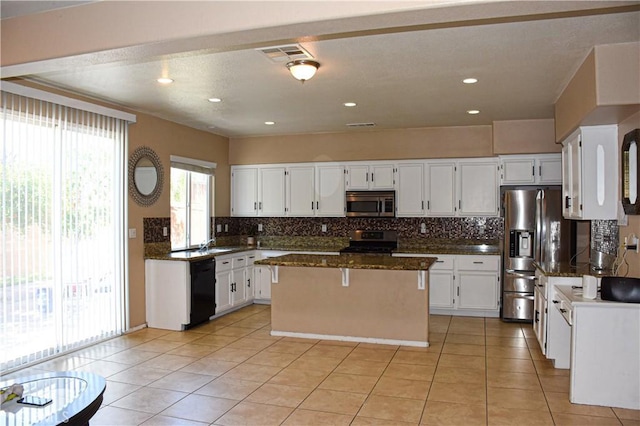 12655 Verano St, Victorville, CA 92392 - kitchen featuring appliances with stainless steel finishes, a center island, decorative backsplash, white cabinets, and recessed lighting