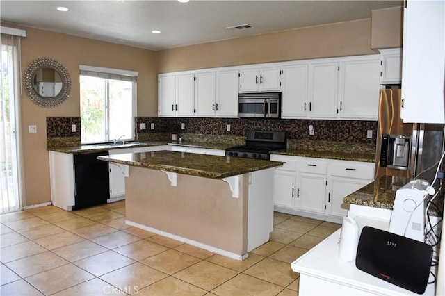12655 Verano St, Victorville, CA 92392 - kitchen with stainless steel appliances, tasteful backsplash, dark stone countertops, a kitchen island, and recessed lighting