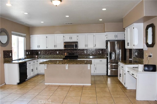 12655 Verano St, Victorville, CA 92392 - kitchen with appliances with stainless steel finishes, dark stone countertops, decorative backsplash, a center island, and recessed lighting