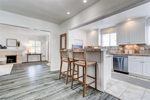 1217 S Gertruda Ave, Redondo Beach, CA 90277 - kitchen with stainless steel dishwasher, a kitchen breakfast bar, healthy amount of natural light, white cabinetry, and recessed lighting