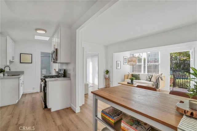 232 Howland Canal, Venice, CA 90291 - kitchen featuring appliances with stainless steel finishes, light countertops, light wood-style flooring, and white cabinets