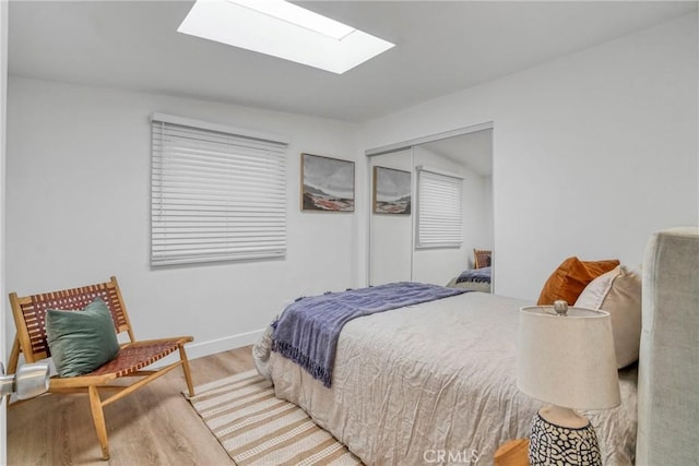 232 Howland Canal, Venice, CA 90291 - bedroom featuring a skylight, wood finished floors, a closet, and baseboards