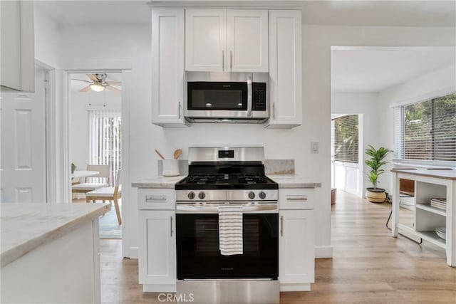 232 Howland Canal, Venice, CA 90291 - kitchen featuring appliances with stainless steel finishes, ceiling fan, light wood-style flooring, and white cabinets