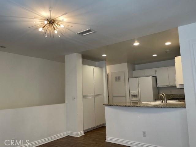 177 Via Colinas, Westlake Village, CA 91362 - kitchen featuring white fridge with ice dispenser, a peninsula, dark wood-style flooring, dark stone counters, and white cabinetry