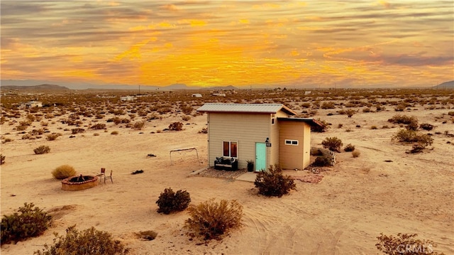 310 Enchanted Rd, Joshua Tree, CA 92252 - view of outdoor structure with view of desert landscape, a mountain view, a fire pit, and a view of countryside