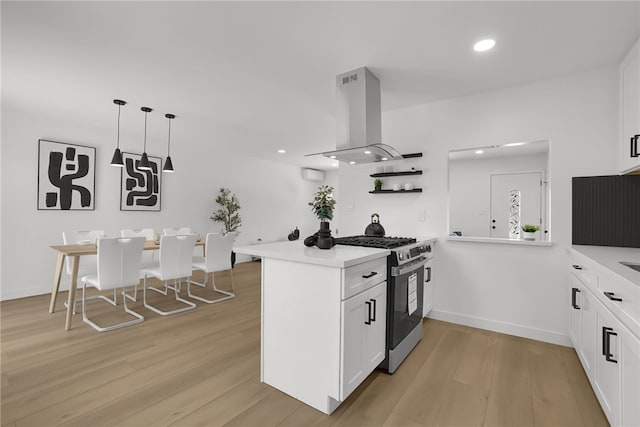 1152 W Tudor St, San Dimas, CA 91773 - kitchen featuring stainless steel gas stove, island exhaust hood, light wood-style floors, white cabinetry, and recessed lighting