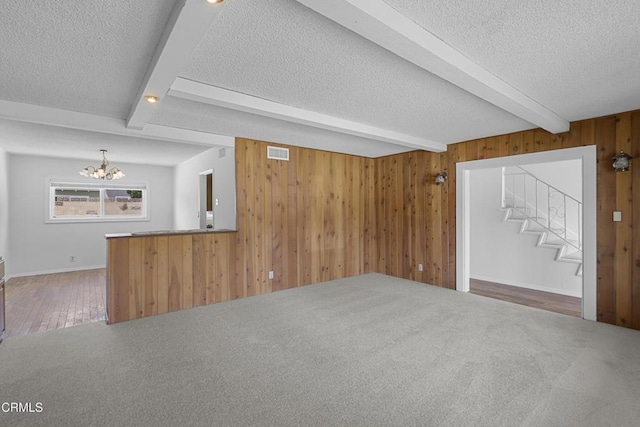 6421 Almar St, Simi Valley, CA 93063 - unfurnished living room featuring beam ceiling, a textured ceiling, a chandelier, wood walls, and stairs