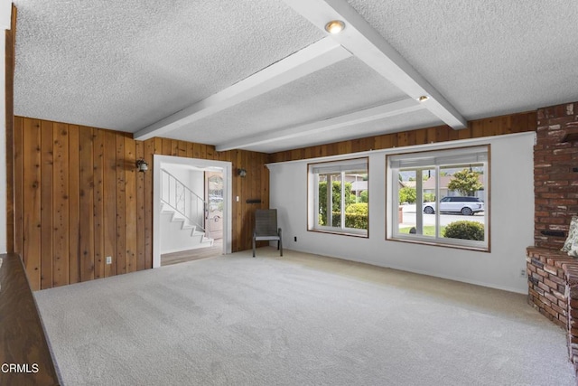 6421 Almar St, Simi Valley, CA 93063 - unfurnished living room with a textured ceiling, beamed ceiling, carpet, stairway, and wood walls