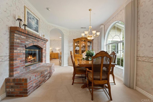 23406 Oakely Pl, Ramona, CA 92065 - carpeted dining space featuring wallpapered walls, a chandelier, ornamental molding, a fireplace, and arched walkways