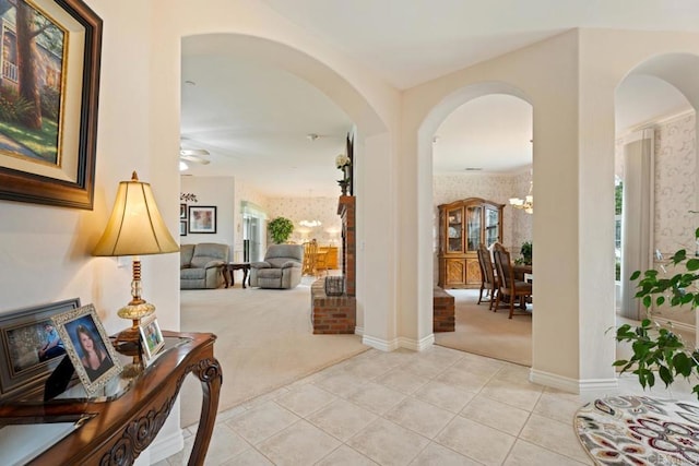 23406 Oakely Pl, Ramona, CA 92065 - entryway featuring light carpet, arched walkways, a chandelier, wallpapered walls, and light tile patterned floors