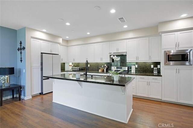 228 Borrego, Irvine, CA 92618 - kitchen featuring appliances with stainless steel finishes, dark wood finished floors, white cabinetry, tasteful backsplash, and recessed lighting