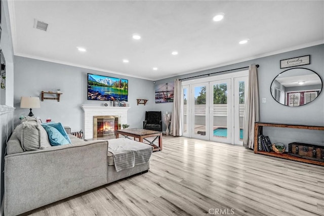 1523 Lynton Ave, Wilmington, CA 90744 - living area with crown molding, wood finished floors, a brick fireplace, recessed lighting, and french doors