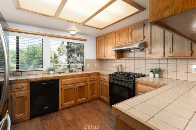 250 Coral Ct, Pismo Beach, CA 93449 - kitchen with black appliances, under cabinet range hood, tile counters, and dark wood-type flooring