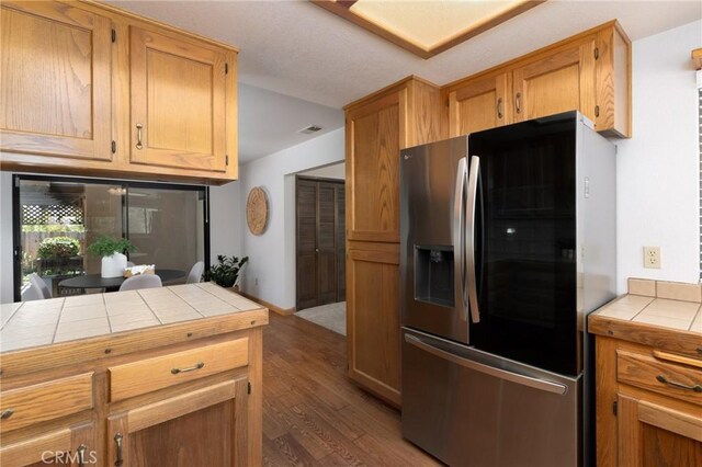 250 Coral Ct, Pismo Beach, CA 93449 - kitchen featuring stainless steel refrigerator with ice dispenser, tile counters, and wood finished floors